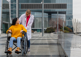 female doctor pushing patient in wheelchair
