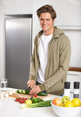 Fototapeta premium Diet, cooking and man cutting vegetables on kitchen counter with salad, wellness and nutrition in home. Wood board, knife and healthy food process with brunch, chef and vegan meal prep in apartment
