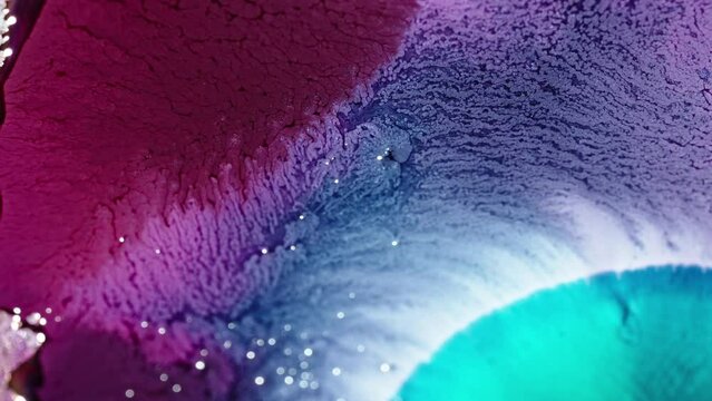 Vibrant purple and blue ink diffusing in water, creating an abstract, flowing texture