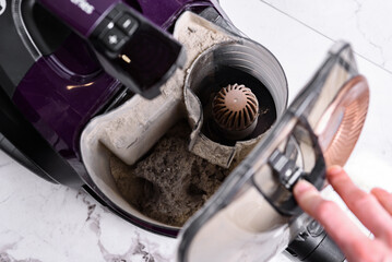 Vacuum cleaner full of garbage after home cleaning.