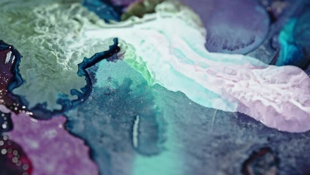 Close-up of vibrant ink colors blending in water, creating an abstract, fluid art piece with a dynamic, ethereal feel