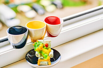 Three cups on the windowsill. Coffee, tea. Break in the office