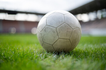 White soccer ball lying on the grass at stadium