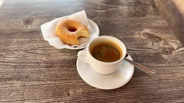 classic donut and coffee cup on wood table in the coffeshop