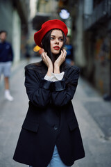 Fashion woman portrait walking tourist in stylish clothes with red lips walking down narrow city street, travel, cinematic color, retro vintage style, dramatic look without smile sadness.