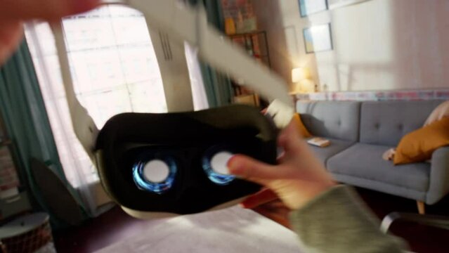 Anonymous Person Putting On a Virtual Reality Headset at Home. User Enters an Animated Digital Internet 3D Office and Takes Part in a Remote Corporate Marketing Meeting with Other Colleagues
