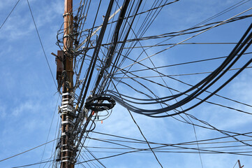 The chaos of cables and wires on an electric pole. - 740647093