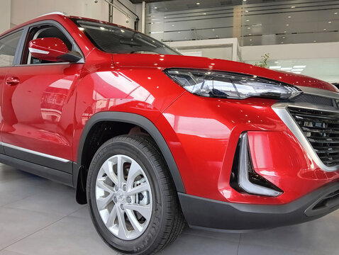 Chinese compact crossover Beijing X3 (BAIC X35) in red is presented to potential buyers in showroom of Hyundai Autoholding Center. Close-up of car. Adygea, Russia – December 15, 2023
