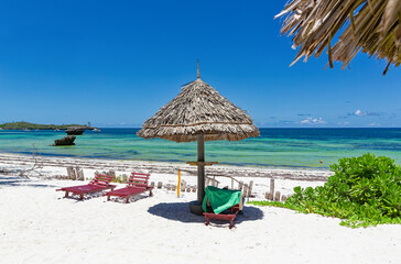 Chair and green trees on a white sand beach. Watamu, Kenya - Africa.