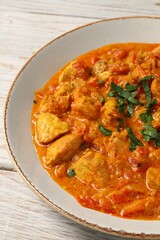 Delicious chicken curry with parsley on wooden table