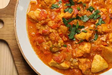 Delicious chicken curry on wooden table, top view