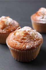 Delicious sweet muffins on black table, closeup