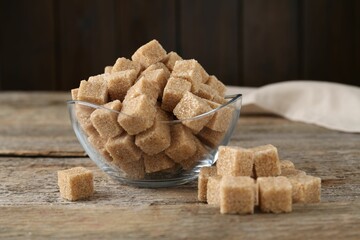 Brown sugar cubes on wooden table, closeup