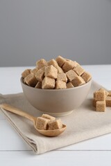 Brown sugar cubes on white wooden table
