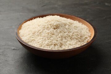 Raw basmati rice in bowl on black table