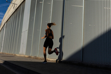 Healthy young woman on morning run. Beautiful fit woman jogging outside.