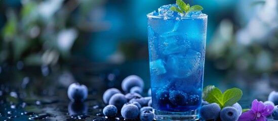 Refreshing blueberry cocktail with ice cubes and freshly picked blueberries for a fruity summer drink - obrazy, fototapety, plakaty