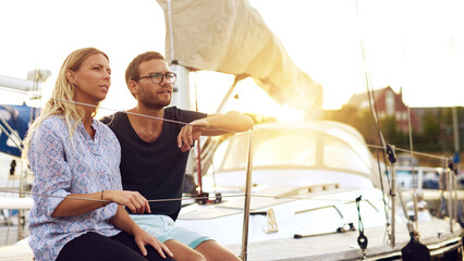 Lovers Sitting on Yacht Deck Looking Into Distance - 740676235