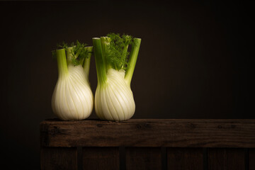 Two fennel bulb on a wooden crate in a still life setting