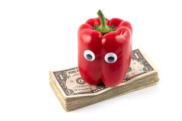 Red bell pepper with eyes on a stack of 1 US dollar bills