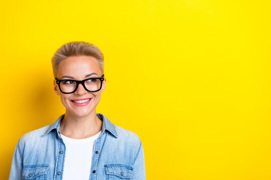 Photo portrait of lovely young lady specs look empty space promo dressed stylish denim garment isolated on yellow color background