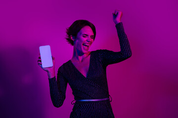 Photo portrait of lovely young lady raise fist white screen dressed stylish overall garment isolated on neon light pink color background