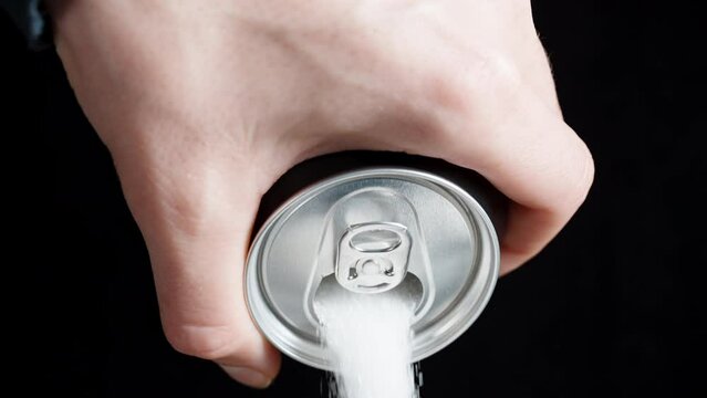 White Sugar is Poured into a Glass from a Soda Can. Concept of Harmful Drinks with High Sugar Content. Slow-Motion, Close-Up.