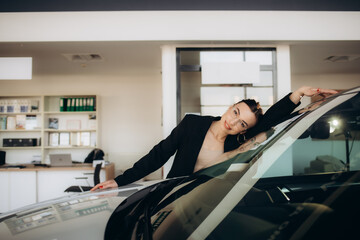 Woman hugging car in a car showroom