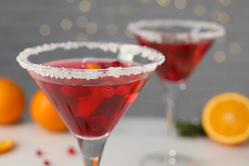 Tasty cranberry cocktail in glasses on light background, closeup
