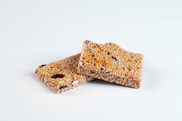 Sesame bar with raisins and dried berries on a white background