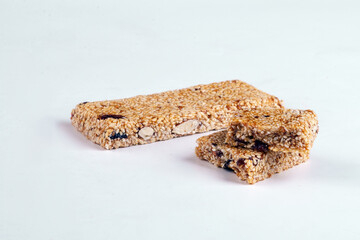 Sesame bar with raisins and dried berries on a white background