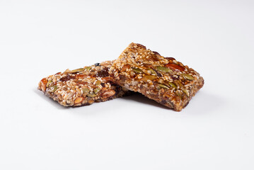 Sesame bar with raisins and dried berries on a white background
