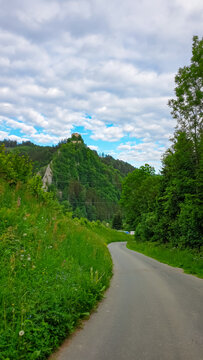 Scenic road leading to medieval castle on a hill in Eppenstein, Mur Valley, Styria, Austria. Ruins of landmark in Weisskirchen in Steiermark. Idyllic forest surrounding tourist attraction. Tranquility