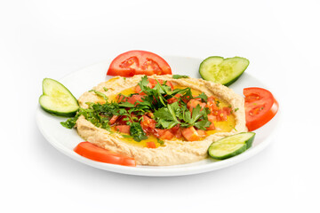Fototapeta na wymiar Top view of arabic mezze hummus served with fresh parsley, sliced tomatoes and cucumber. The ingredients of hummus are chickpeas, tahini and various spices.