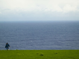 Fototapeta premium Tourist at cliff, Sao Miguel island, Azores travel concept.