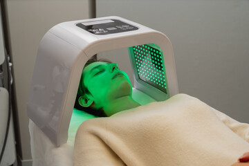 Treatment of women's facial skin using LED light in a beauty salon.