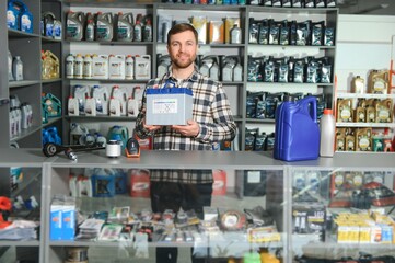 Portrait of a handsome salesman in an auto parts store. The concept of car repair
