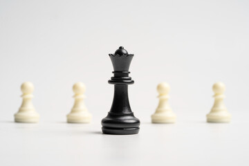 Black queen chess standing in front of white pawn chess for leadership concept.