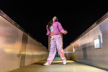 Artist dancing hip hop on a bridge at night