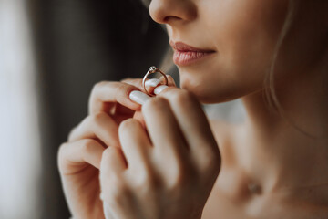 Close-up of an elegant diamond ring on a woman's finger with a modern manicure, sunlight. Love and wedding concept. Soft and selective focus. - obrazy, fototapety, plakaty