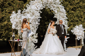 A female wedding presenter giving a speech and the bride and groom