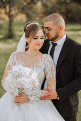 A young bride and groom tenderly embrace in the rays of the autumn sun. Tender and beautiful young...