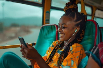 Poster A young african girl sitting on the bus smiling at her phone © dobok