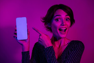 Photo portrait of attractive young woman point white screen wear trendy overall clothes isolated on neon light pink color background