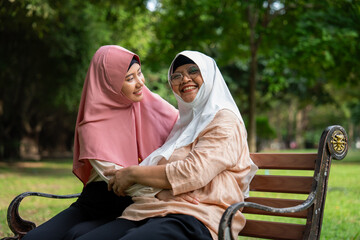 Muslim careful caregiver or nurse taking care of the patient in the hospital park. Happy Muslim...