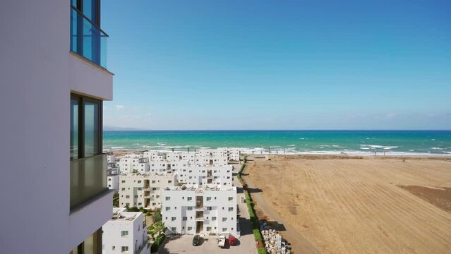 Luxury penthouse balcony overlooks oceanfront, showcasing beach view, high-rise investment property tour