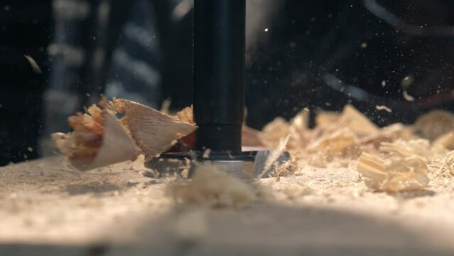 Dive into the world of woodworking with this slow-motion footage capturing a forestry drill in action, sending wood chips swirling into the air.