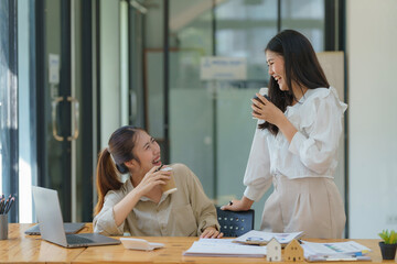 Business relax concept, Two Asian businesswomen enjoying a casual conversation with coffee cups in...