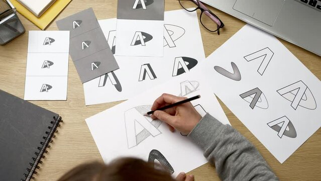 Logo design and creation. The designer draws a sketch of the brand on paper.
