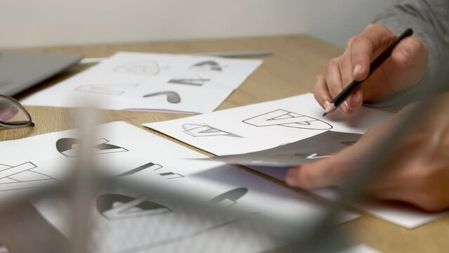 Logo design and creation. The designer draws a sketch of the brand on paper.